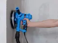 Utensile blu per levigare il muro, ideale per capire come togliere la vernice dal muro.