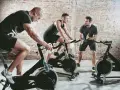 Trainer instructs men on stationary bikes. This workout can help build endurance, proving a stationary bike helps with running.