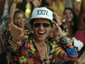 Bruno Mars w Polsce! Wesoły artysta w kolorowej koszuli i czapce z napisem "XXIV K" tańczy wśród rozbawionych ludzi.