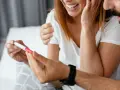 Para trzyma w dłoni test ciążowy, z radością na twarzy. Czy jestem w ciąży?