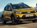 Żółty Dacia Duster, jeden z wielu popularnych dacia modele, jedzie po krętej drodze nad morzem.