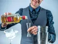 Barman nalewa Olmeca Tequila Gold do jiggera, idealna tequila do margarity. Obok kieliszek z lodem i shaker.