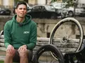 Ciclista con due ruote da bici, una più grande per maggiore velocità.