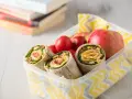 Kolorowy lunchbox z tortillami, jabłkami i pomidorkami. Idealne zdrowe przekąski dla dzieci na szkolny dzień.