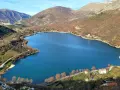 Panoramica del lago di Scanno, con montagne sullo sfondo e case sparse lungo la riva. Un luogo incantevole da esplorare.