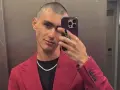Achille Costacurta, con un look audace e un sorriso enigmatico, sembra affrontare i suoi problemi con stile, sfoggiando un completo fucsia e una collana scintillante.