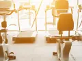 Rzędy bieżni i rowerów stacjonarnych czekają na trening. Idealne miejsce na cardio na siłowni, by poczuć energię.