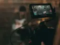 Kamerafilmung einer Band für die Sync-Lizenzierung. Auf dem Monitor ist eine Frau mit Gitarre zu sehen.