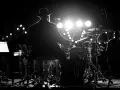 Perkusista w kapeluszu gra na bębnach podczas koncertu MTV Unplugged Polska.