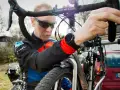 Man i cykelkläder fokuserar på att laga punktering på sin cykel.