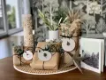 Schöne Geschenk verpacken Ideen: Geschenke in braunes Papier, mit Zweigen und Anhängern dekoriert, neben einer Adventskerze und einer Weihnachtskarte.