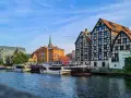 Bydgoszcz atrakcje: Łucznik na linie nad Brdą, nowoczesna architektura i zabytkowe kamienice tworzą malowniczy widok.