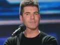 Simon Cowell, znany z surowych ocen, siedzi przy mikrofonie. Plotki o tym, że Simon Cowell nie żyje, są fałszywe.