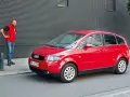 Mann steht neben rotem Audi A2, der für seine audi a2 schwachstellen bekannt ist.