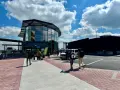 Ludzie z bagażami idą do nowoczesnego terminalu lotniska w Brukseli Charleroi.
