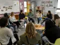 Des participants échangent lors d'une formation, peut-être des stages BAFA, dans une salle colorée.