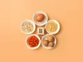En ägg, havregryn, pasta, havtorn och valnötter arrangerade runt en träkub med bokstaven B, som symboliserar alla b-vitaminer.