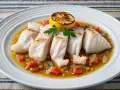 Filetes de pescado blanco, con tomate y limón asado, listos para ser disfrutados. ¡Un pez ballesta se come así de bien!