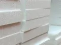 Stos białych płyt styropianowych EPS, gotowych do izolacji.