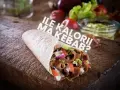 Pyszny kebab z mięsem, warzywami i sosem na desce. Ile kalorii ma kebab?