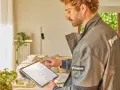 Técnico revisa datos en tablet para el mantenimiento de bomba de calor.