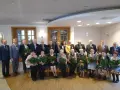 Grupa osób świętuje 50 rocznicę ślubu. Wszyscy otrzymują róże i medale.