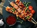 Hähnchenspieße mit glänzender Teriyaki-Sauce, Sesam und Kirschtomaten. Ein köstliches teriyaki sauce rezept zum Nachmachen.