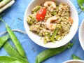 Deliziosa insalata di cereali con gamberetti, pomodorini, asparagi e fave. Un piatto fresco e nutriente.