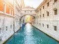 Il Ponte dei Sospiri a Venezia, con la sua leggenda di condanne e addii, si staglia maestoso sul canale azzurro.