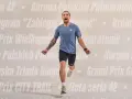 Mężczyzna w stroju sportowym biegnie, krzycząc z radości. Tło ozdobione nazwami biegów w Polsce, jak Korona Polskich Półmaratonów.