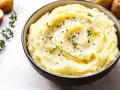 En skål med krämigt potatismos lyx, toppat med örter och peppar. Perfekt som tillbehör till middagen.