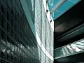 Mur extérieur en pose brique de verre, reflétant la lumière et créant des jeux d'ombres sur la façade moderne.