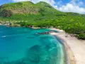 Spiaggia tropicale con acque turchesi e montagne verdi. Un luogo perfetto per scoprire cosa vedere a Capo Verde, tra relax e natura.