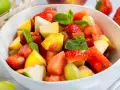 Ein bunter Obstsalat mit Erdbeeren, Melone, Pfirsich und Trauben – ein einfaches obstsalat rezept für heiße Tage.