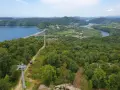 Widok na zielone wzgórza nad Soliną, z widoczną zaporą, jeziorem i kolejką gondolową. Trasa widokowa zachwyca.