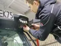 Mężczyzna dokonuje wymiany żarówki w lampie roboczej pojazdu.