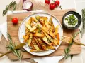 Knusprige rosmarinkartoffeln aus dem Airfryer, garniert mit frischem Rosmarin und Sesam. Dazu ein Dip.