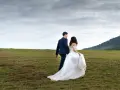 Para, kto nie może być świadkiem na ślubie kościelnym, to osoba nieochrzczona. Para młoda idzie przez łąkę.