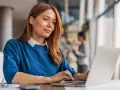 Frau am Laptop, die über ihr teilzeit gehalt pro monat nachdenkt.
