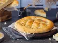 Frisch gebackenes Fladenbrot mit Sesam und Schwarzkümmel, bereit zum Genießen. Selbst Fladenbrot backen ist eine Freude!