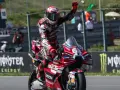 Piloto de MotoGP celebra victoria en su moto Ducati roja. Aunque no se especifica cuanto mide Marc Márquez, su presencia en la pista es imponente.