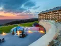 Luksusowy hotel z basenem i jacuzzi na tle zachodzącego słońca. Jeden z największych hoteli w Polsce oferuje relaks w malowniczej scenerii.