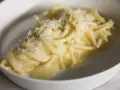 Un piatto di pasta burro e parmigiano, cremoso e invitante, con una spolverata di formaggio grattugiato.