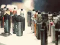 Botellas de líquidos para vapear, con diversos potenciadores de sabor, y dispositivos electrónicos en exhibición.