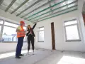 Inżynier i architektka omawiają projekt podwieszanego sufitu w nowym budynku.