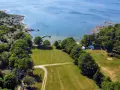 Vacker vy över camping i Blekinge med husvagnar vid en brygga och grönskande skog.