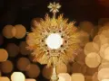 Złota monstrancja z hostią, otoczona promieniami i rubinami, symbolizuje pierwsze piątki miesiąca.