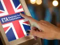 Dłoń naciska ekran z flagą Wielkiej Brytanii i napisem ETA Electronic Travel Authorization. To krok do uzyskania wizy do Anglii.