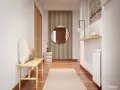 Un pasillo estrecho con espejos que amplían el espacio. Un banco de madera, cojines y una alfombra crean un recibidor acogedor.