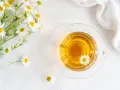Un mazzolino di margherite e una tazza di tisana dorata. Nonostante la sua apparenza innocua, la camomilla fa male al cuore se consumata in eccesso.